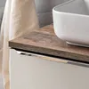 A close-up view of a bathroom vanity cabinet with a wooden countertop and a white ceramic sink. Produktbild-Vorschau