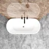 A top-down view of a freestanding oval bathtub with a marble-patterned wall behind it and tiled flooring. Produktbild-Vorschau