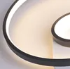 A close-up view of a modern LED ceiling lamp with a black frame and illuminated white light. Produktbild-Vorschau