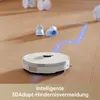 A robot vacuum cleaner navigates a wooden floor, avoiding obstacles like shoes and other objects, with a blue dotted line indicating its path. Produktbild-Vorschau