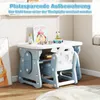 A child's desk and chair set with toys on top, set against a light-colored wall and floor. Produktbild-Vorschau