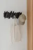 A wall-mounted coat rack with a tote bag and a cap hanging on it. Náhľad obrázku produktu
