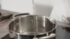 Water being poured into a stainless steel pot with measurement markings. Anteprima dell’immagine prodotto