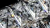 A close-up, detailed view of a faceted crystal or glass object, likely part of a chandelier or decorative fixture, against a dark background. Podgląd zdjęcia produktu
