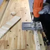 A person is using a drill with a jig to create holes in a wooden plank. Náhľad obrázku produktu