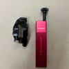 A black clamp and a red tool are placed on a light brown surface. Produktbild-Vorschau