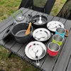 Camping cookware set laid out on a table outdoors. Produktbild-Vorschau