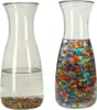 Two glass carafes are shown side-by-side against a white background. The left carafe contains water and a small amount of dry gel beads at the bottom. The right carafe contains water and a large quantity of hydrated, colorful gel beads. Náhled obrázku produktu