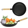 A frying pan with a wooden handle is shown above a close-up of chopped vegetables in a pan. Podgląd zdjęcia produktu