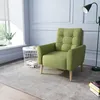 A green armchair is placed in a well-lit room with a window, a side table, and a floor lamp. Voir les images du produit