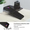 A black flip phone case is shown on a wooden surface, with a camera lens in the background. A smaller inset image shows the case with a cracked effect at the bottom. Náhled obrázku produktu