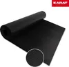 A black rubber mat with a ribbed texture, rolled up on one end and unrolled on the other, shown on a white background. A close-up inset shows the texture of the mat. A red logo with white text is in the top right corner. Náhled obrázku produktu