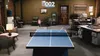 An office setting with a ping pong table set up for a game. Podgląd zdjęcia produktu