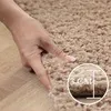 A hand is shown pressing into a thick, shaggy carpet, with a circular overlay indicating the carpet's thickness. Podgląd zdjęcia produktu