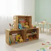 A child's play area with wooden crates used for storage, toys, and books. Produktbild-Vorschau