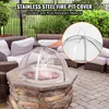 A fire pit cover is placed on a stone fire pit on a patio, with outdoor furniture in the background. Produktbild-Vorschau