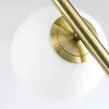 A close-up view of a lamp's glass shade and brass fixture. Náhľad obrázku produktu
