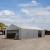 A large gray tent structure is set up outdoors on a gravel surface, with stacks of wooden pallets visible inside. Produktbild-Vorschau