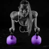A woman is performing a push-up exercise with kettlebells. Podgląd zdjęcia produktu