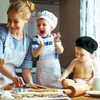 A mother and her children are baking cookies in a kitchen. Produktbild-Vorschau