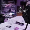 A person in black gloves is using an airbrush to paint a component of a ROKR 3D-Puzzle Marble-Run 'The Future City'. Voir les images du produit