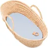A woven bassinet with a pastel blue sheet and a small wooden teether. Produktbild-Vorschau