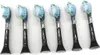 Six black toothbrush heads with blue and green bristles, each with a clear plastic protective cover, are arranged in a row against a white background. Produktbild-Vorschau