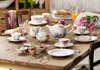 A beautifully set table for tea or coffee, featuring a Villeroy & Boch Mariefleur Basic tea set with floral decorations, pastries, tulips, and orange juice. Podgląd zdjęcia produktu