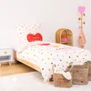 A child's bedroom with a bed, nightstand, and storage baskets, decorated with a heart theme. Náhled obrázku produktu