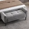 A grey upholstered bench with tufted detailing is placed in front of a bed in a bedroom setting. Anteprima dell’immagine prodotto