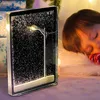 A child sleeping next to a decorative snow globe with a street lamp. Produktbild-Vorschau