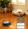 A robot vacuum cleaner is cleaning a wooden floor next to a dog sleeping in its bed. A smartphone app interface is overlaid on the bottom right. Anteprima dell’immagine prodotto