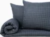 A folded duvet and two pillows with a grid pattern. Náhled obrázku produktu