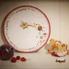 A Christmas-themed plate with gingerbread decorations and a wooden rocking horse. Náhled obrázku produktu