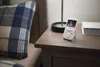A baby monitor is placed on a nightstand next to a bed. Produktbild-Vorschau