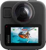 The back of a black GoPro MAX2 camera is shown, displaying its screen which shows a video of a person skydiving from a helicopter. Produktbild-Vorschau
