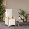 A beige poly rattan garden chair with a cream cushion is placed on a tiled patio next to a small side table with a cup and a lantern. A lush green plant is in the background. Náhľad obrázku produktu