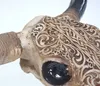 A close-up view of a decorative bull skull with intricate carvings. Podgląd zdjęcia produktu