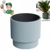 A cartoon gardener giving a thumbs up and holding a garden tool, next to a light blue ribbed planter. A smaller inset image shows a green ribbed planter with a plant. Anteprima dell’immagine prodotto
