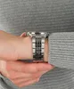 A close-up side view of a person's wrist wearing a silver watch. Náhľad obrázku produktu