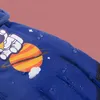 A close-up of a blue children's glove with a space-themed design, showing water droplets on the surface. Produktbild-Vorschau