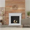 A white bioethanol fireplace is shown in a living room setting with a wooden wall, a clock, a shelf with decorative items, and a chair. Podgląd zdjęcia produktu
