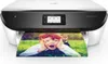 A white and black HP printer is printing a photo of a young boy. Voir les images du produit
