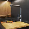 A modern kitchen sink area with a faucet, cutting board, and oranges. Náhled obrázku produktu