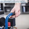 A hand holding a blue hose connected to a compressor. Produktbild-Vorschau