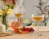 A table setting with champagne glasses, fruit, and flowers. Náhľad obrázku produktu