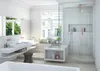 A modern, luxurious bathroom with a large window, a built-in bench, a double vanity, and a glass-enclosed shower. Voir les images du produit