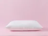 A white pillow is centered on a pink background. Produktbild-Vorschau