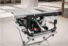 A table saw with its stand is shown in a workshop or construction environment. Náhľad obrázku produktu