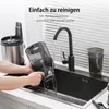A person is rinsing a part of a juicer under a faucet in a kitchen sink. The text on the image indicates it is easy to clean. Produktbild-Vorschau